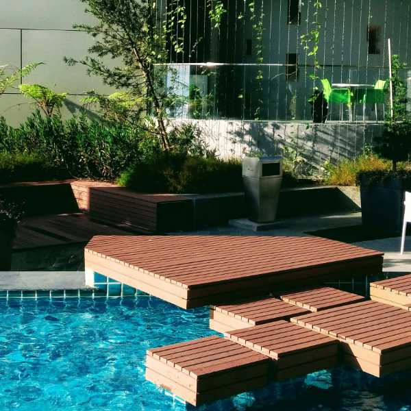 Modern pool design with wood and concrete retaining wall